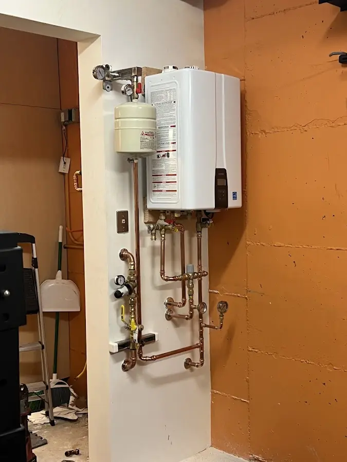 Plumbing technician inspecting water heater connections in Fountain Hill